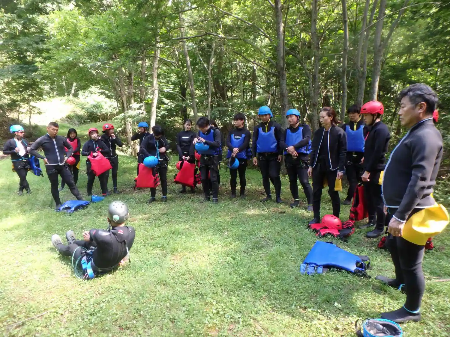 (水上)みなかみ半日キャニオニングアドベンチャー開始前に森の空き地でみなかみキャニオニング安全説明会, Minakami canyoning safety briefing session in forest clearing before minakami half day canyoning adventure begins