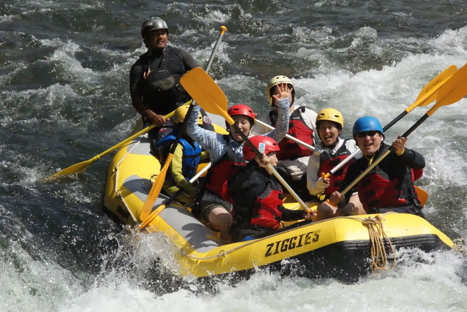 （水上）みなかみラフティングチームが黄色いZiggiesボートでみなかみ半日ラフティングツアー中にエキサイティングな急流をパドリング。Minakami rafting team paddling through exciting rapids during minakami half day rafting tour on yellow Ziggies raft.